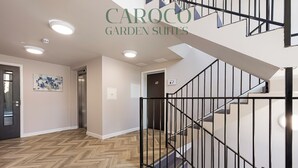 A modern interior with a herringbone wood floor, a staircase with black railings, and recessed ceiling lighting. - Westciti Caroco Aparthotel (Croydon)