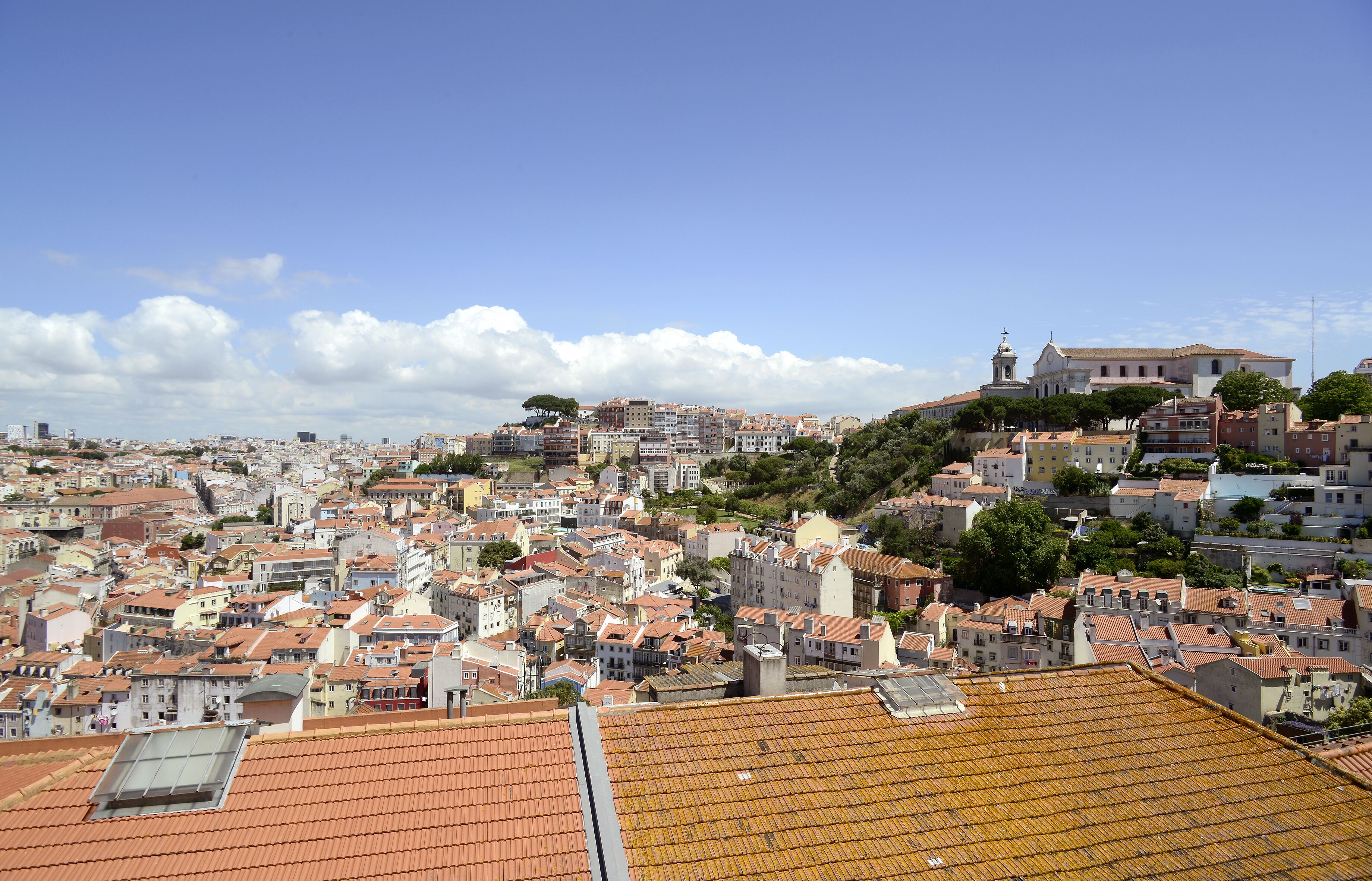 A densely packed urban area with a variety of building styles and a prominent church on a hill.