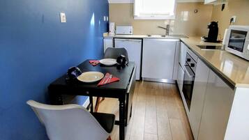 Departamento superior, 1 habitación, vista a la ciudad | Cocina privada | Refrigerador con congelador, microondas, horno y parrilla de estufa