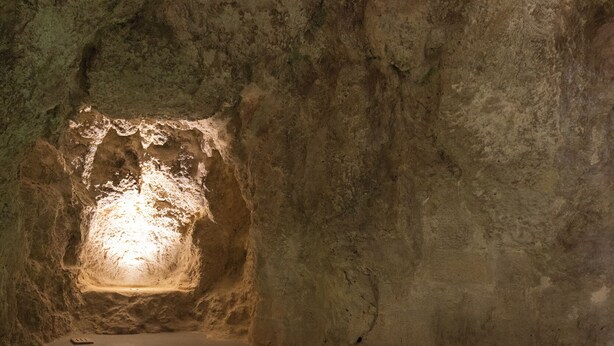 Un'area benessere con vasca idromassaggio e parete in pietra.