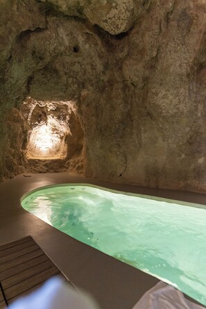 Un área de spa con un jacuzzi y una pared de piedra.