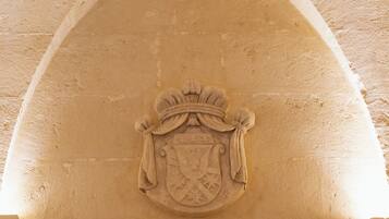 Une arche en pierre ornée d’un blason.