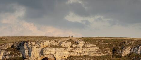 A rocky landscape with a person standing on a hill.