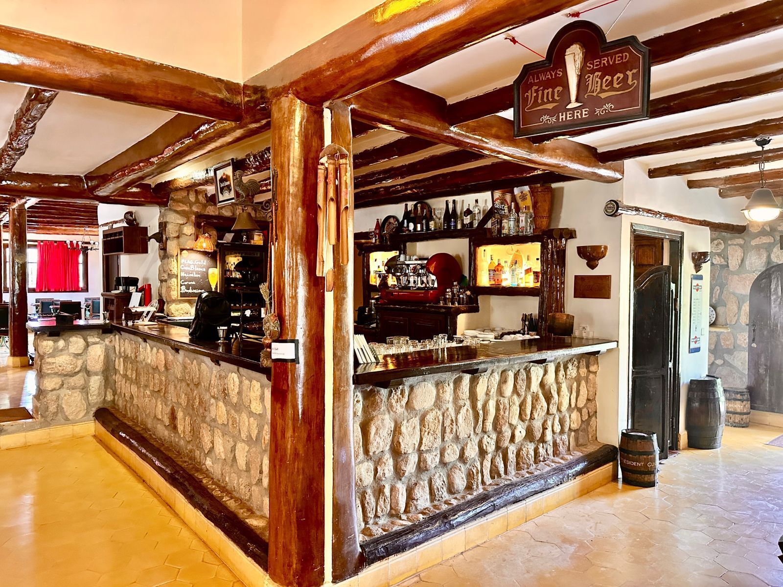 A bar area with a stone counter, wooden beams, and a sign indicating 'Fine Beer'.