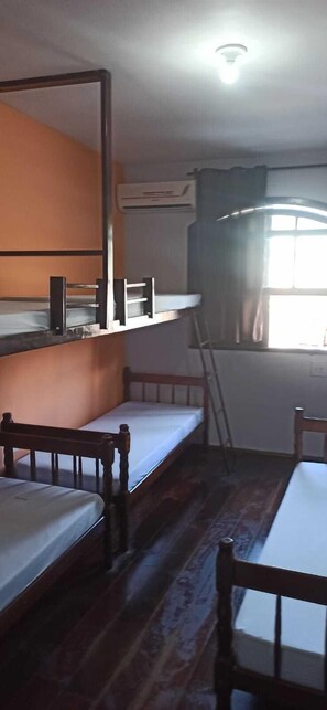 A compact room with bunk beds, a small table, and a ladder. - 365 Hostel (Angra dos Reis)