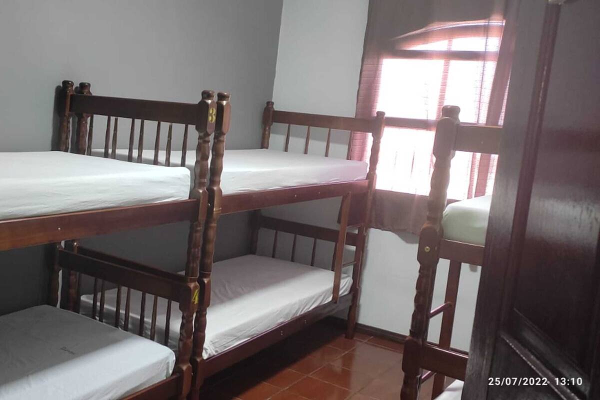A bunk bed room with a window and a door.