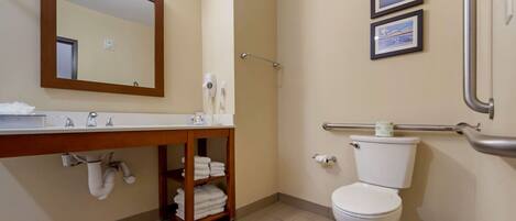 A bathroom with a sink, mirror, toilet, and towel rack.