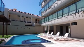 Alberca al aire libre y camastros 