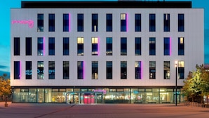 Een modern gebouw met een witte gevel en veel ramen.