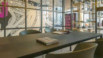 Une bibliothèque moderne dotée d’une grande fenêtre qui offre une vue détaillée sur une illustration représentant un paysage urbain.