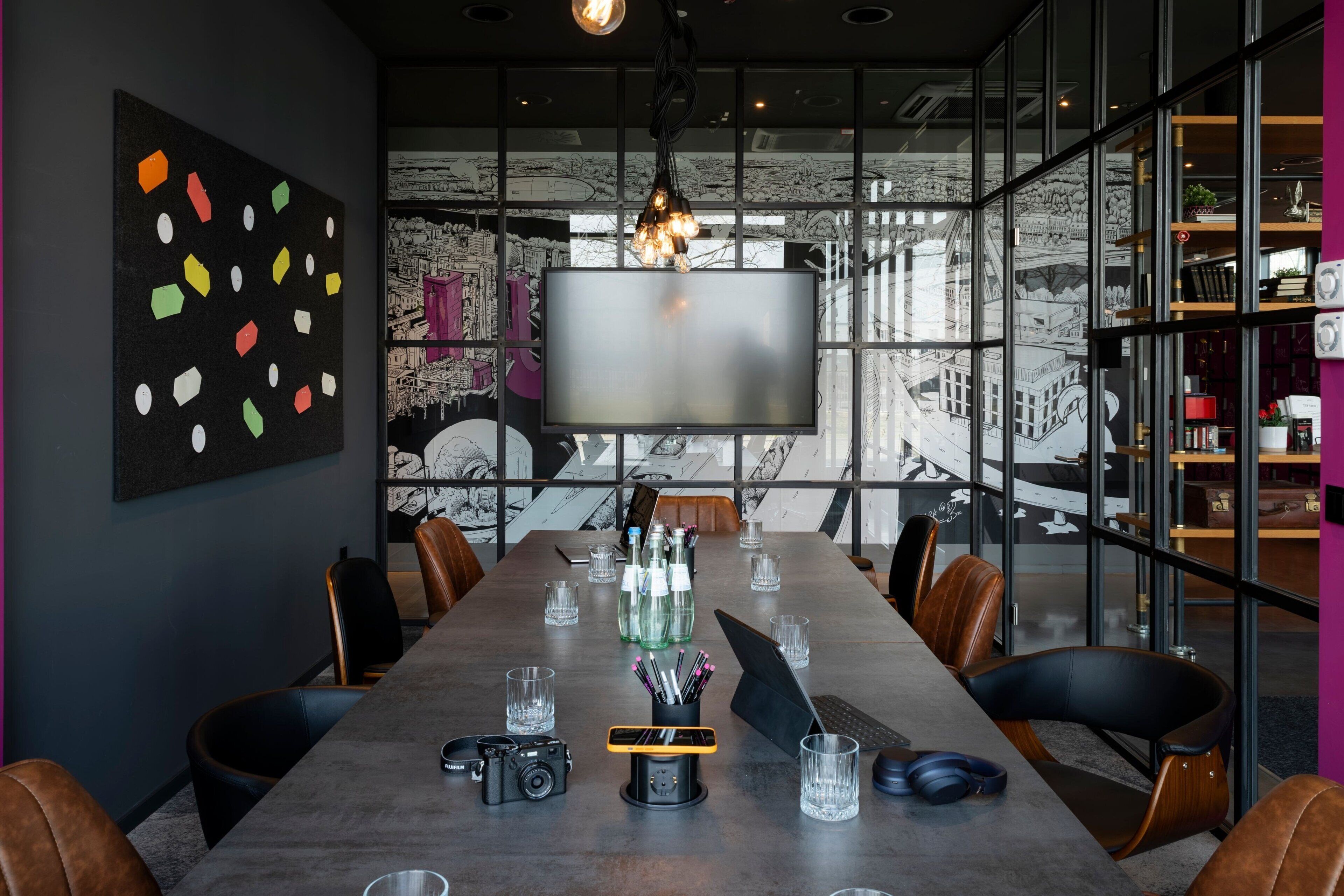 Una sala de reuniones moderna con una larga mesa, sillas de cuero, una pantalla grande y un mural con vistas a la ciudad en las paredes.