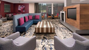 Ein stilvoller Lounge-Bereich mit Ecksofa, Sesseln, Couchtisch und Flachbildfernseher.