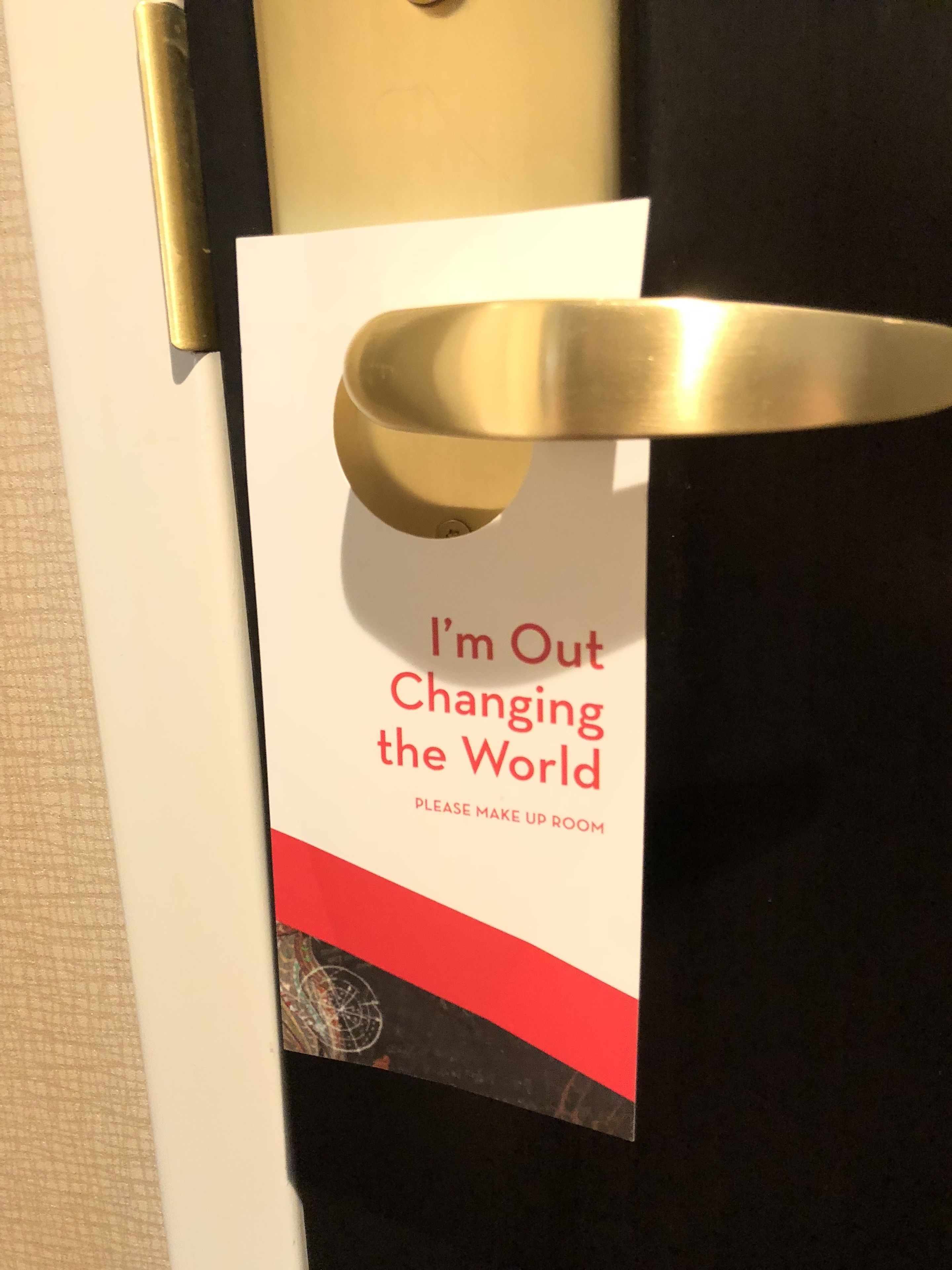 Une porte avec une pancarte sur laquelle on peut lire : « Je suis parti changer le monde » et « Veuillez préparer la chambre ».