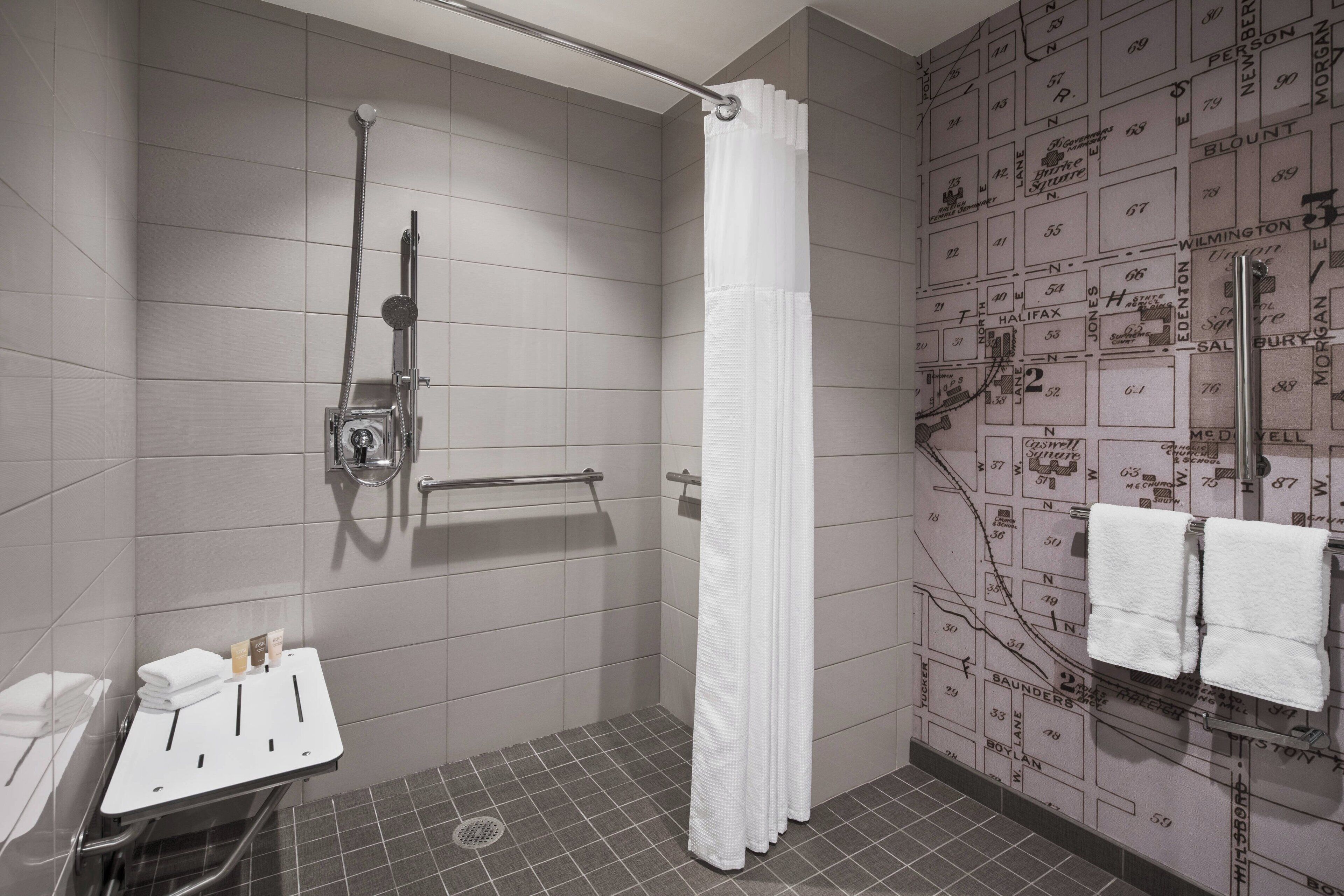 A modern bathroom with a shower, a toilet, and a sink.