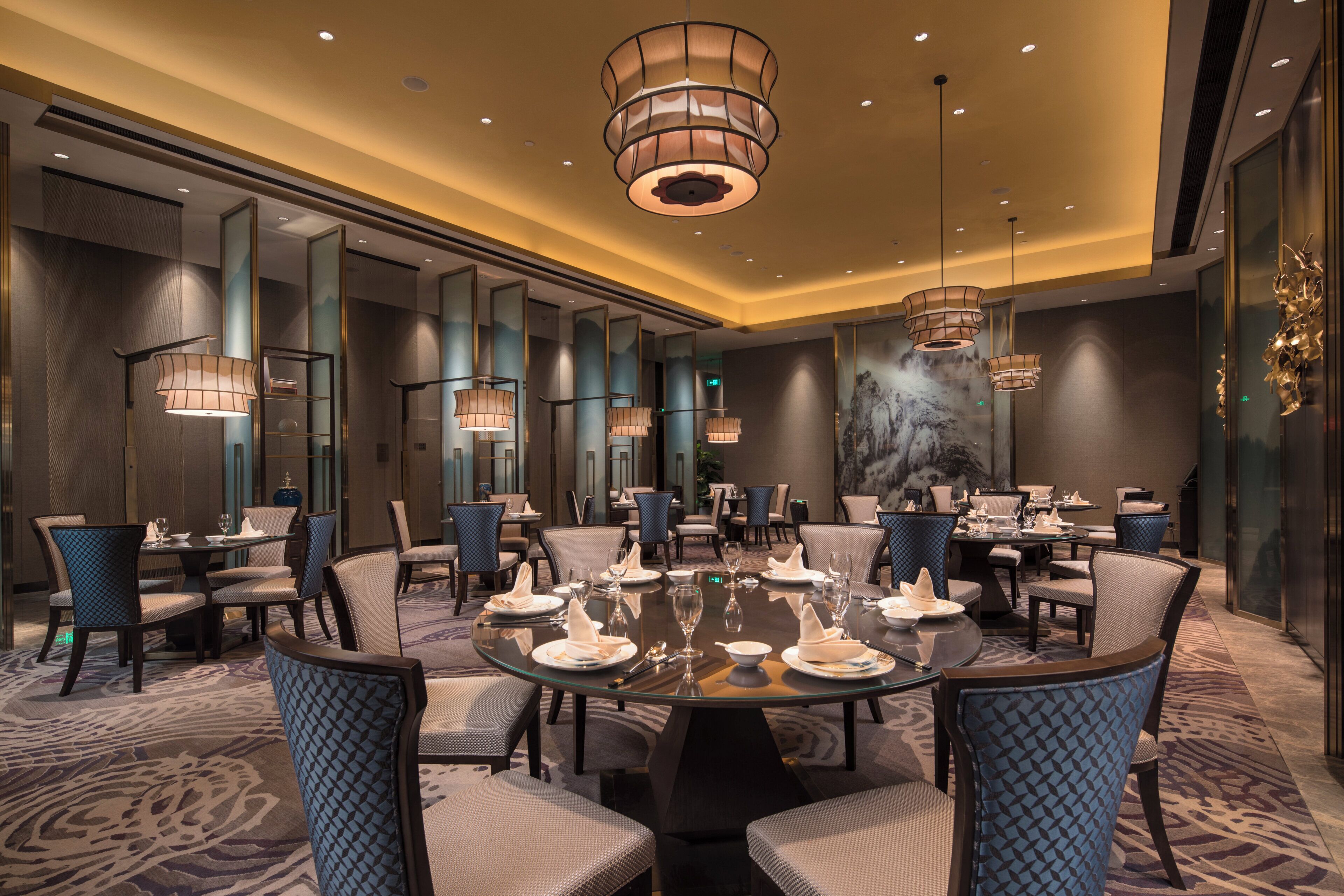 A conference room with a round table, chairs, and a large chandelier.