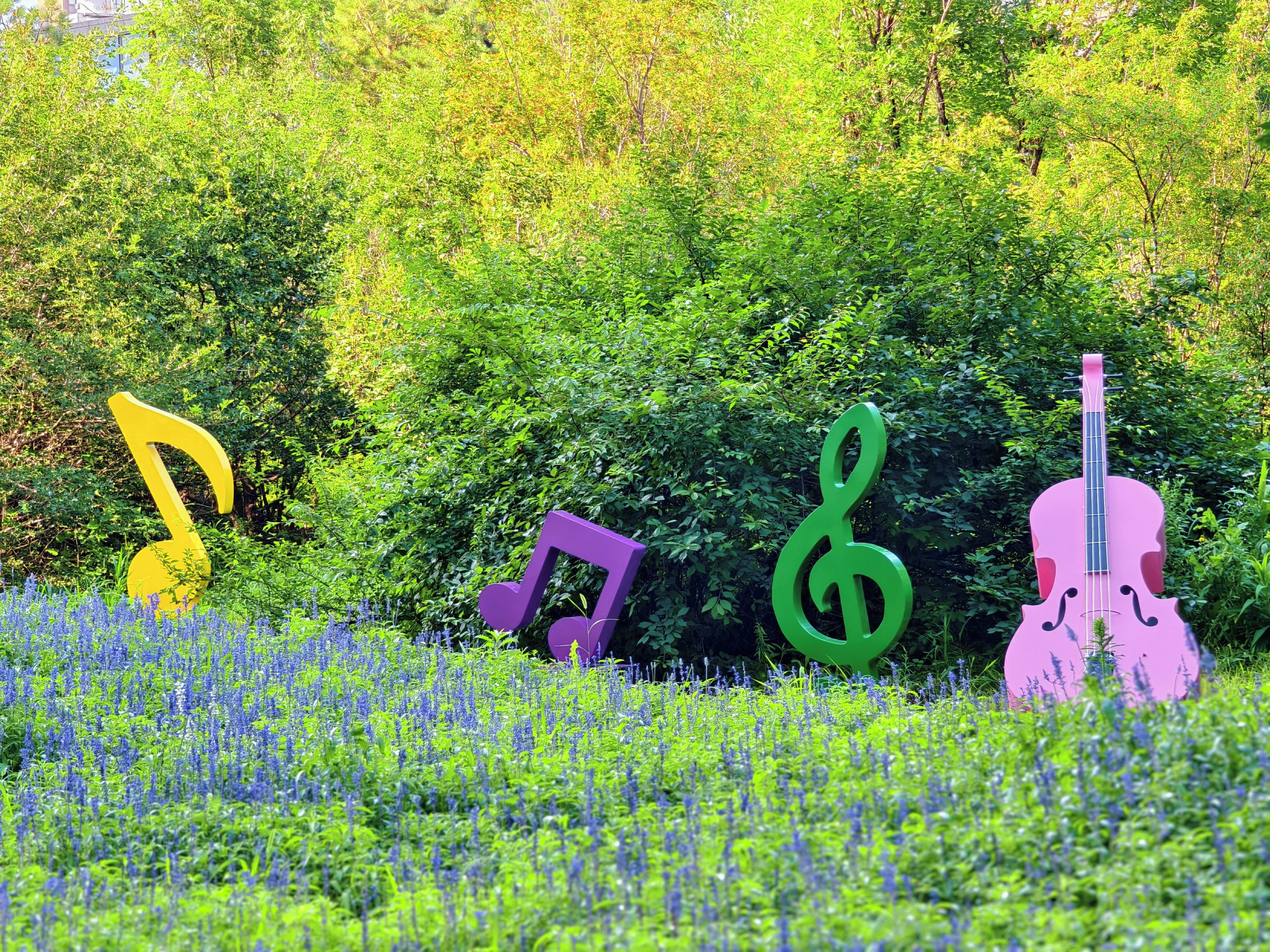 Un jardin agrémenté de sculptures en forme de notes de musique et d’un violon.