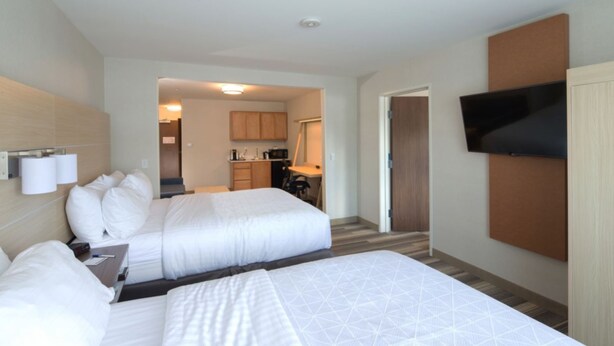 A hotel room with two beds, a TV, a desk, and a kitchenette. - Holiday Inn Express and Suites Portage by IHG (Portage)
