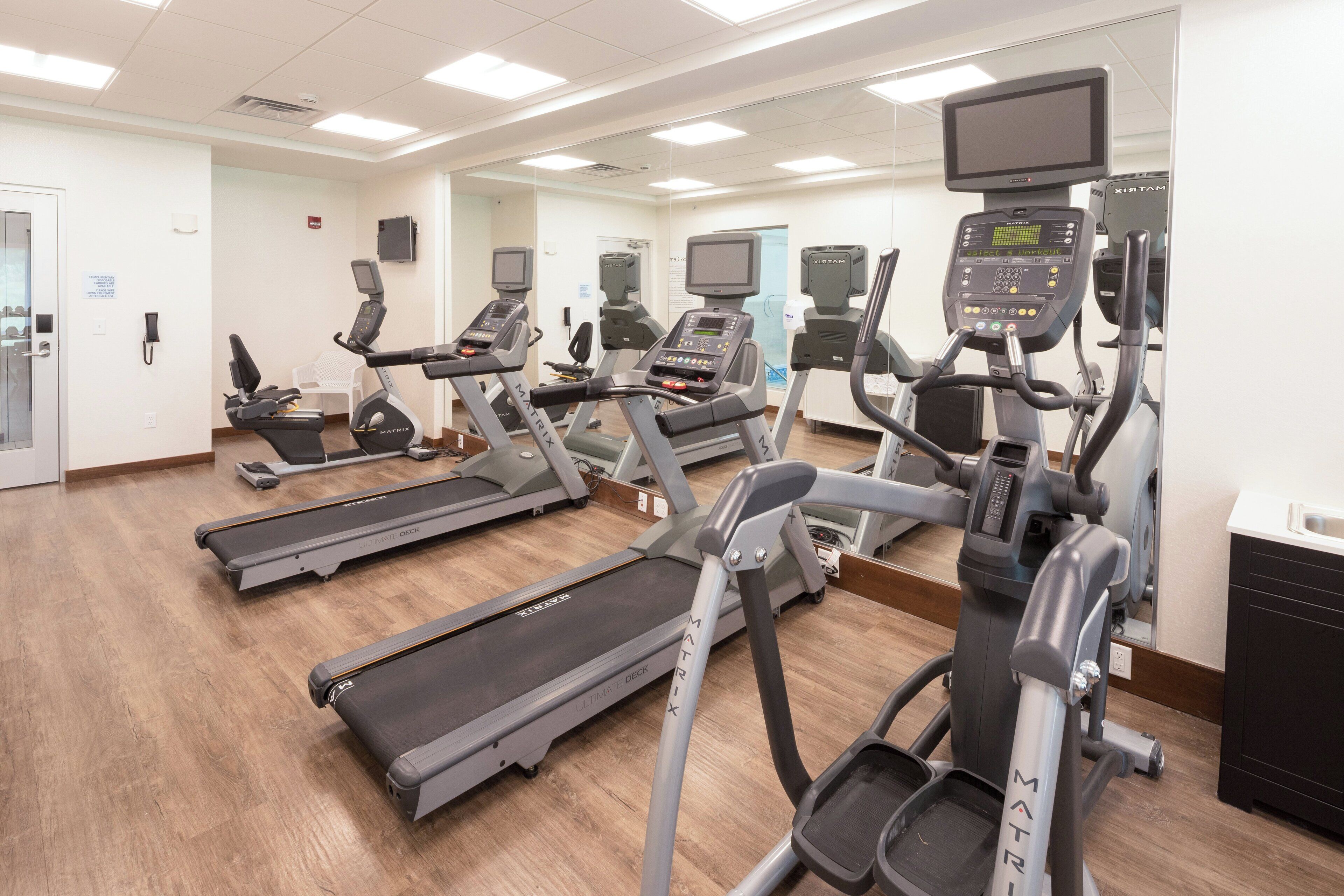 Un gimnasio equipado con cintas de correr, elípticas y bicicletas estáticas.