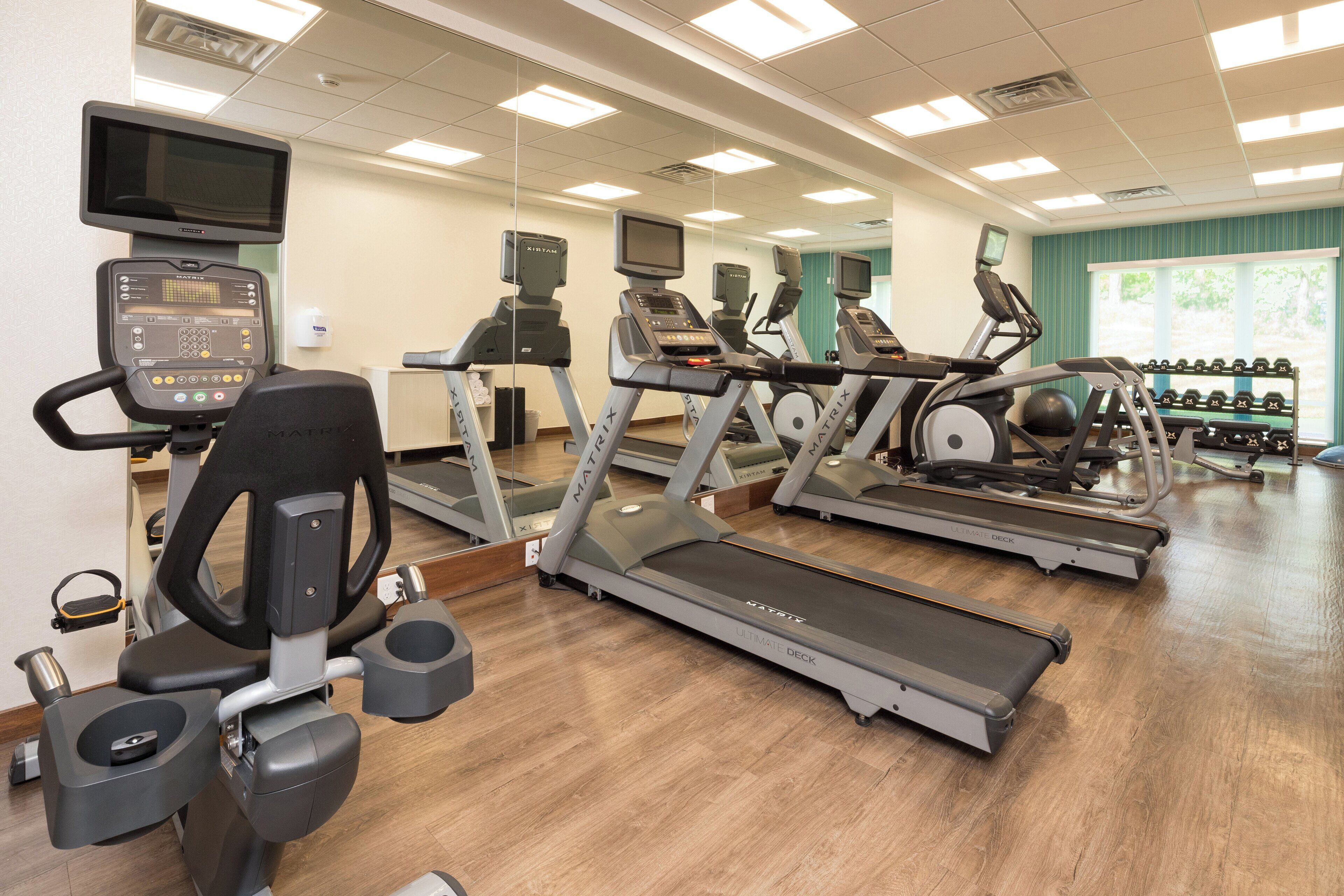 A gym with treadmills, elliptical machines, and a rowing machine.