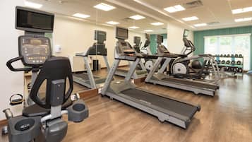 A gym with treadmills, elliptical machines, and a rowing machine.