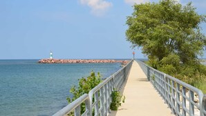 A coastal walkway with a lighthouse, trees, and a clear sky. - Holiday Inn Express and Suites Portage by IHG (Portage)