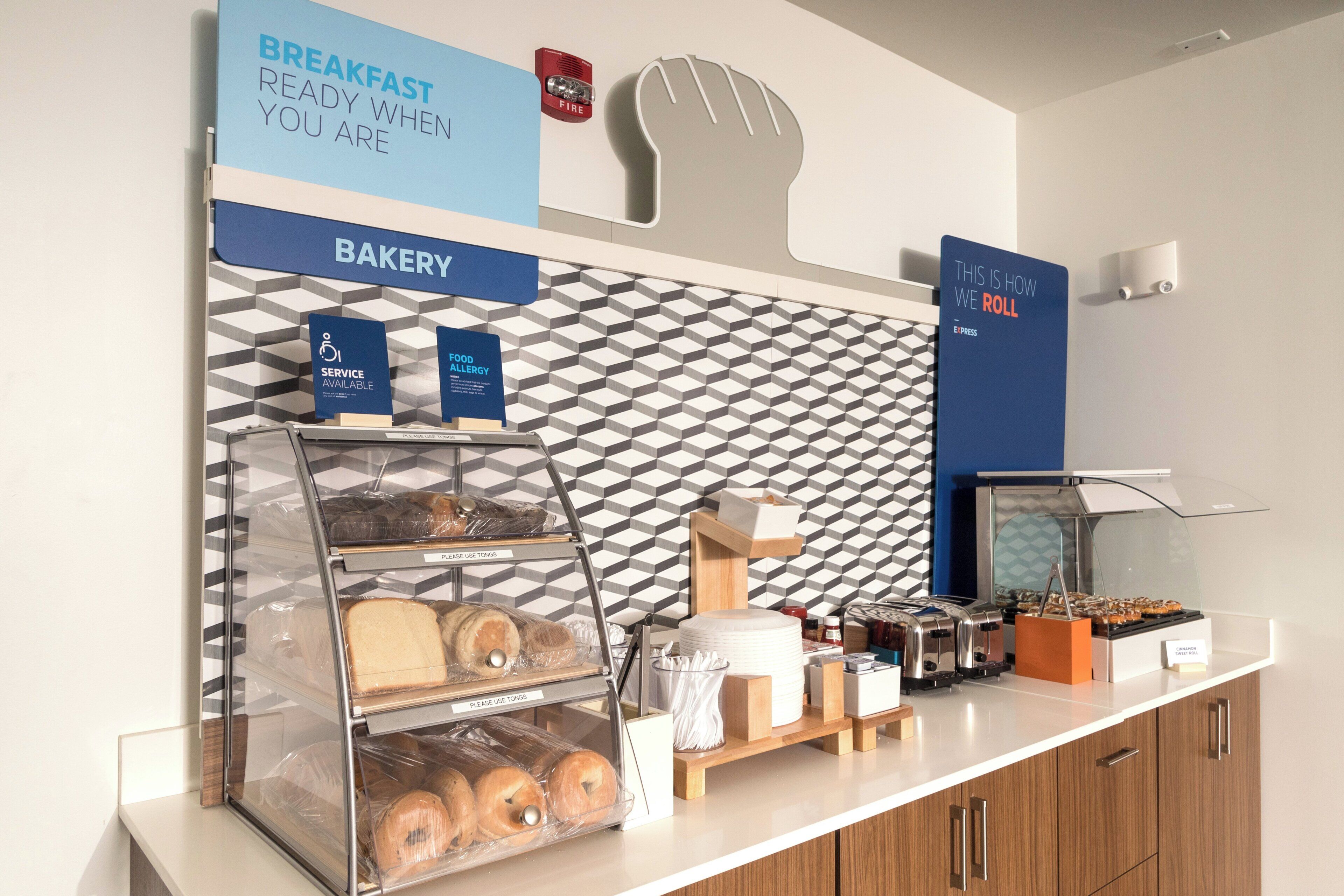 A bakery counter with bread, a toaster, and a sign indicating service for food allergies.