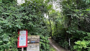 A trail sign with warnings about wet conditions and closures. - Holiday Inn Express and Suites Portage by IHG (Portage)