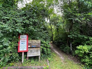 A trail sign with warnings about wet conditions and closures. - Holiday Inn Express and Suites Portage by IHG (Portage)