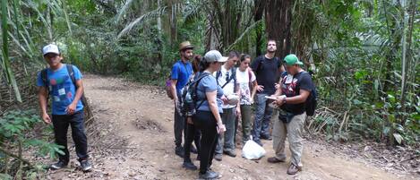 A group of people standing on a dirt path in a forested area.