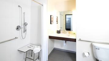 A modern bathroom with a shower, toilet, and sink.