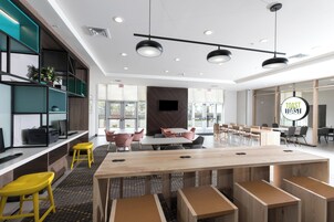 Una sala de conferencias moderna con una mesa larga, varias sillas y estanterías empotradas.