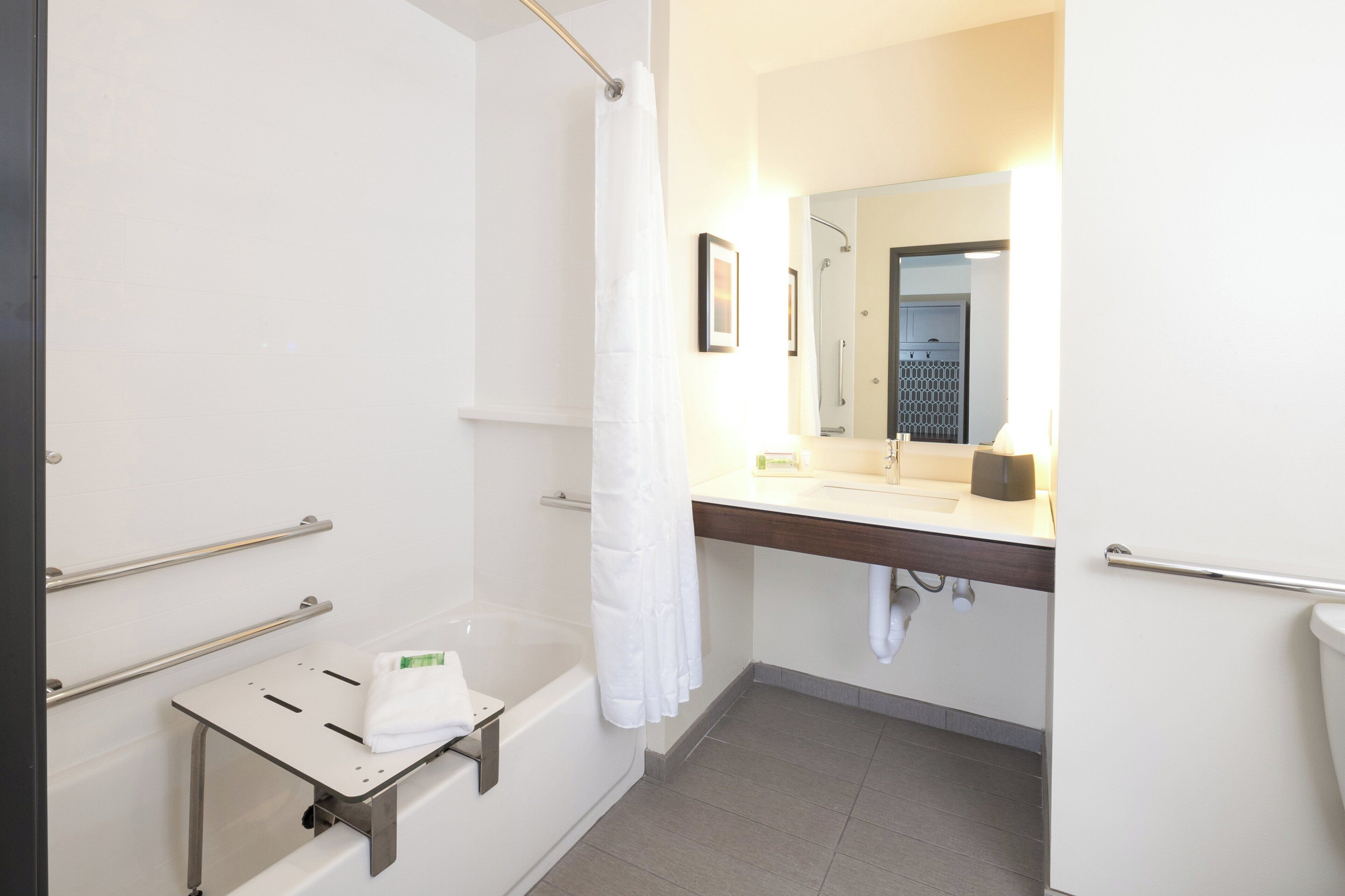 Ein Badezimmer mit Dusche, Waschbecken und Spiegel.