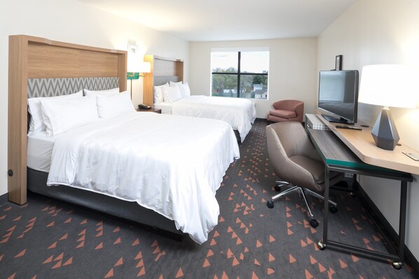 A hotel room with two beds, a desk with a television, and a view of the outside. - Holiday Inn Hotels and Suites Mount Pleasant by IHG (Mount Pleasant)