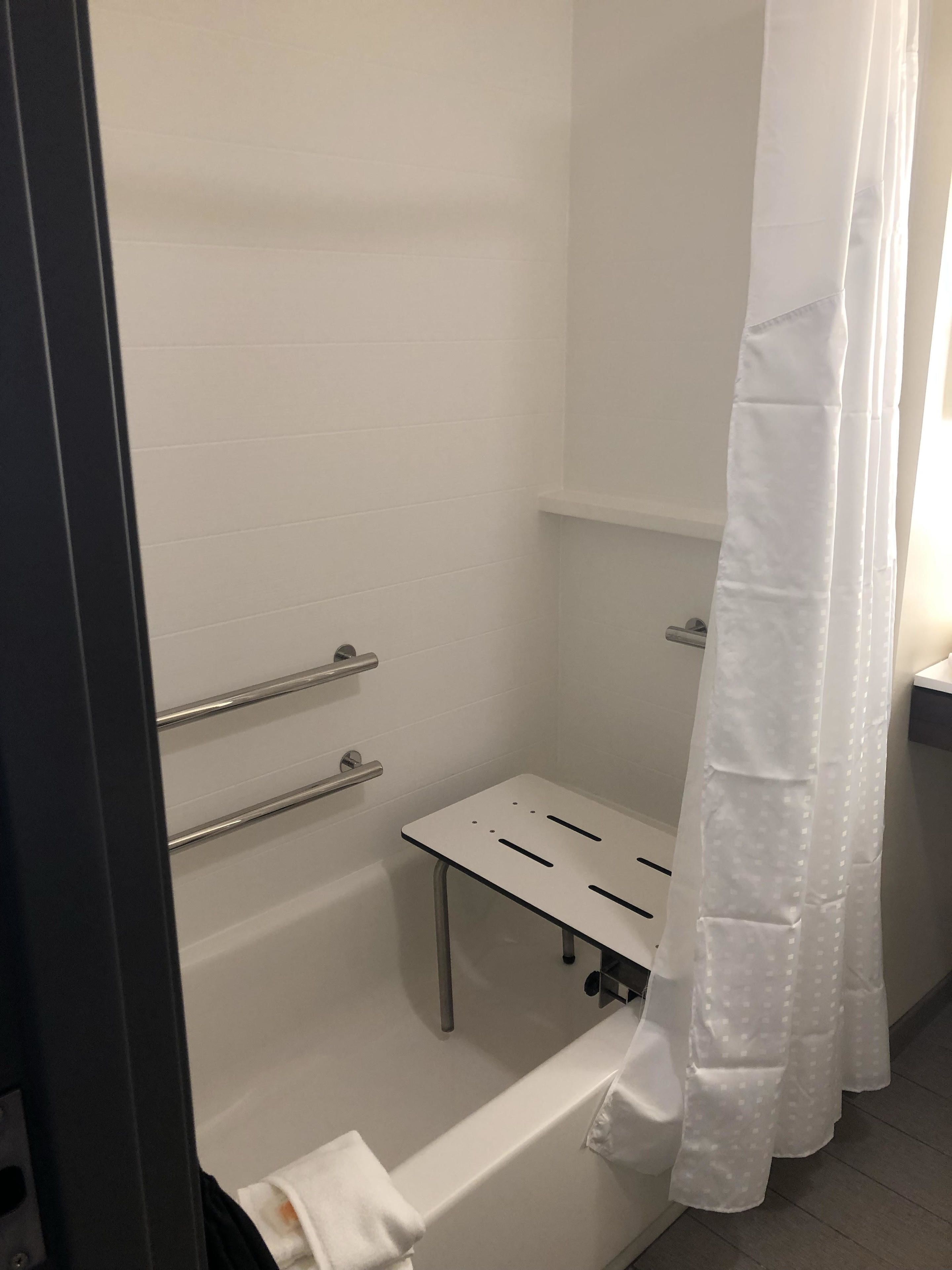 A bathroom with a shower, a toilet, and a sink.