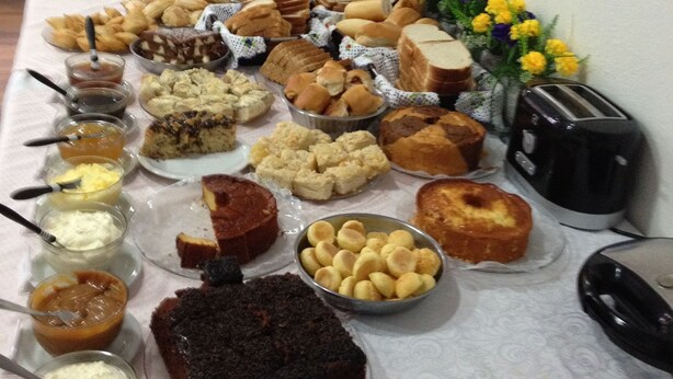 A buffet table with various food items and a toaster. - Hotel Pousada XV (Blumenau)