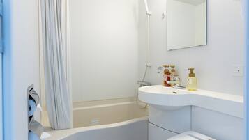 Un baño moderno con bañera, lavamanos y espejo.