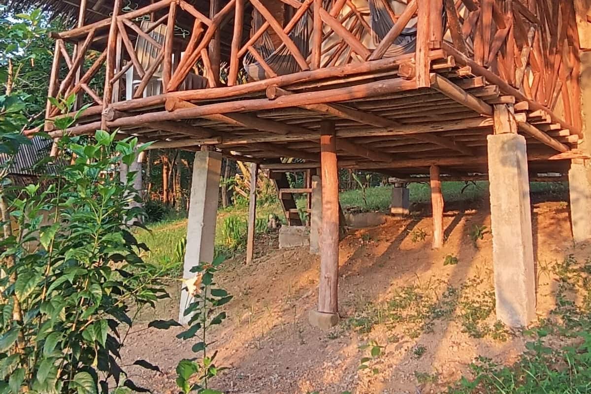 Une construction rustique en bois, dotée d’un toit de chaume et d’un balcon en bois.