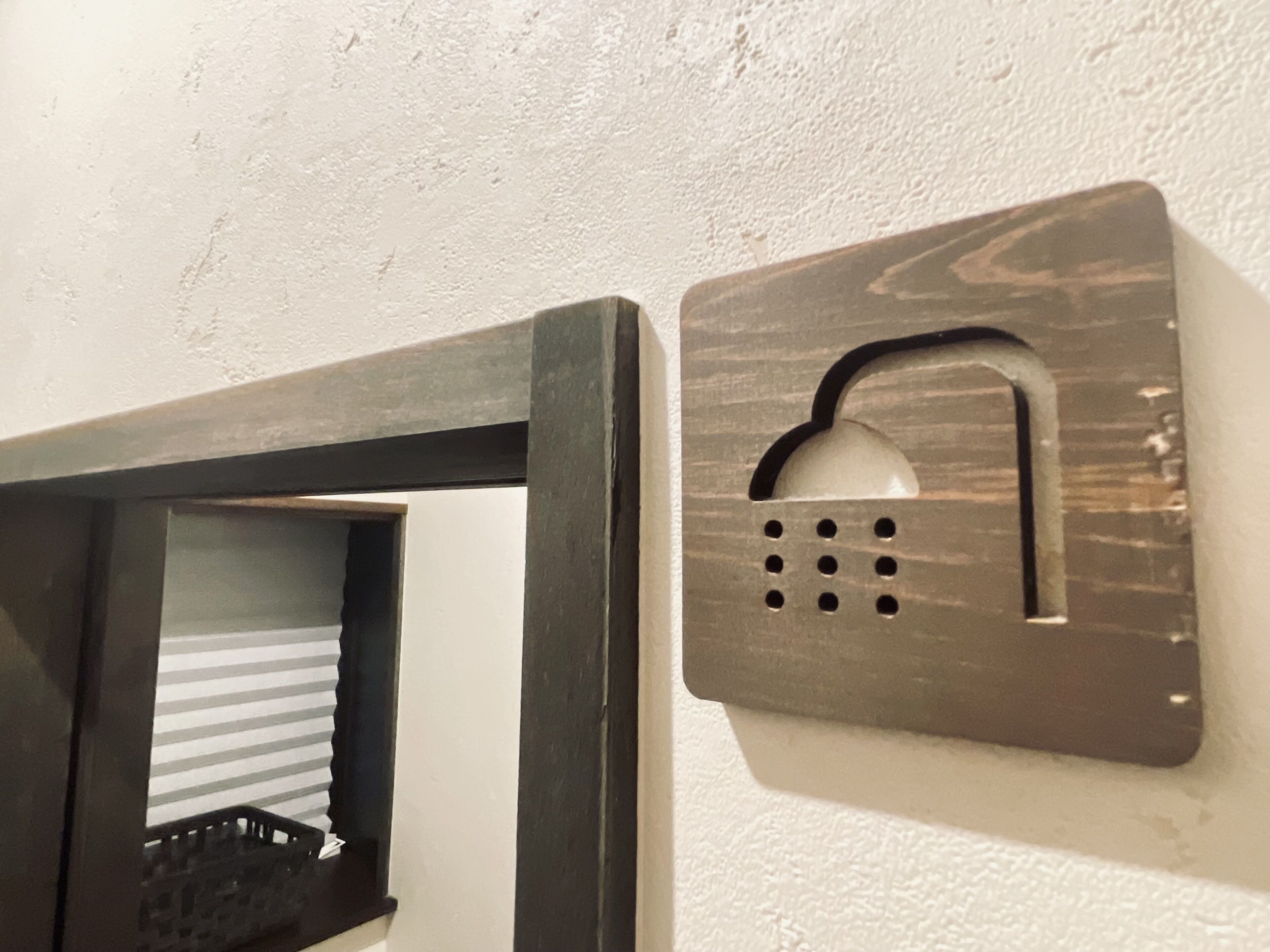 A wall-mounted intercom with a rectangular design and a recessed speaker grille.