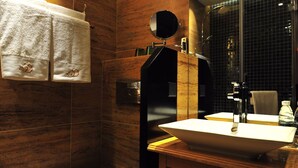 Un bagno moderno con un mobile bagno in legno, un lavandino bianco e un water.