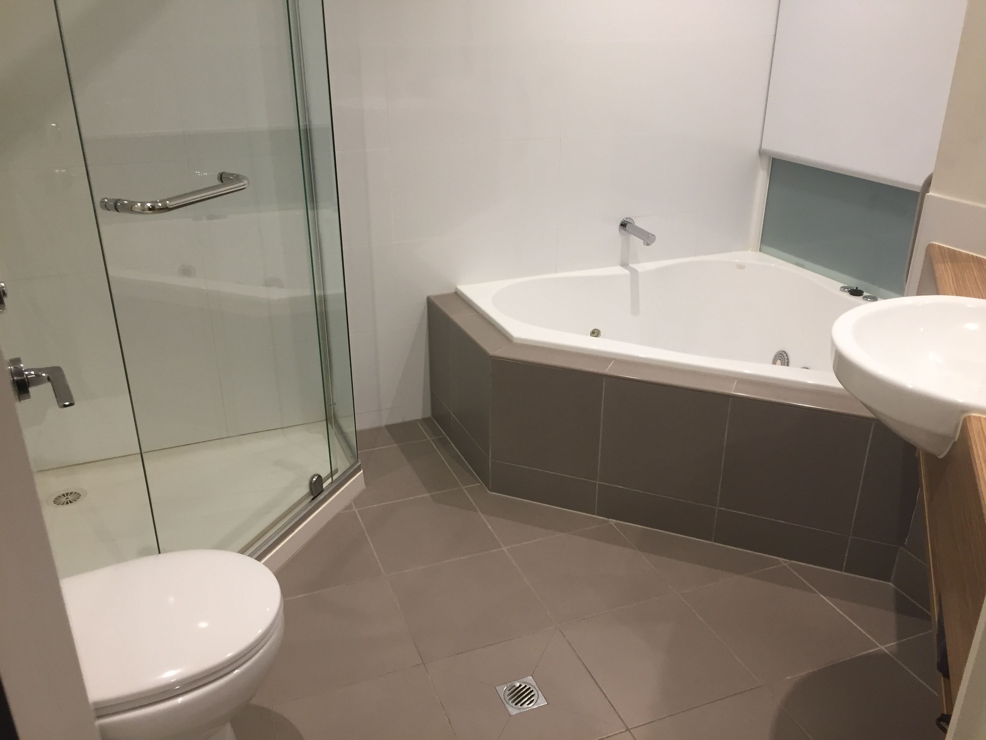 Un baño moderno con cabina de ducha de vidrio, una bañera independiente y un lavamanos.