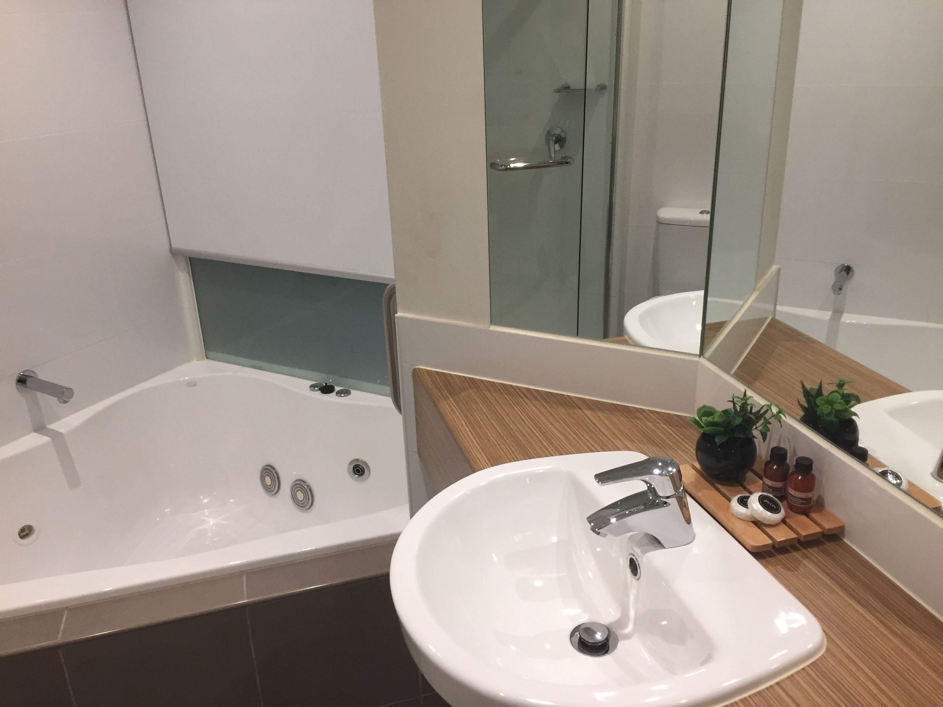 A modern bathroom with a bathtub, a sink, and a mirror.