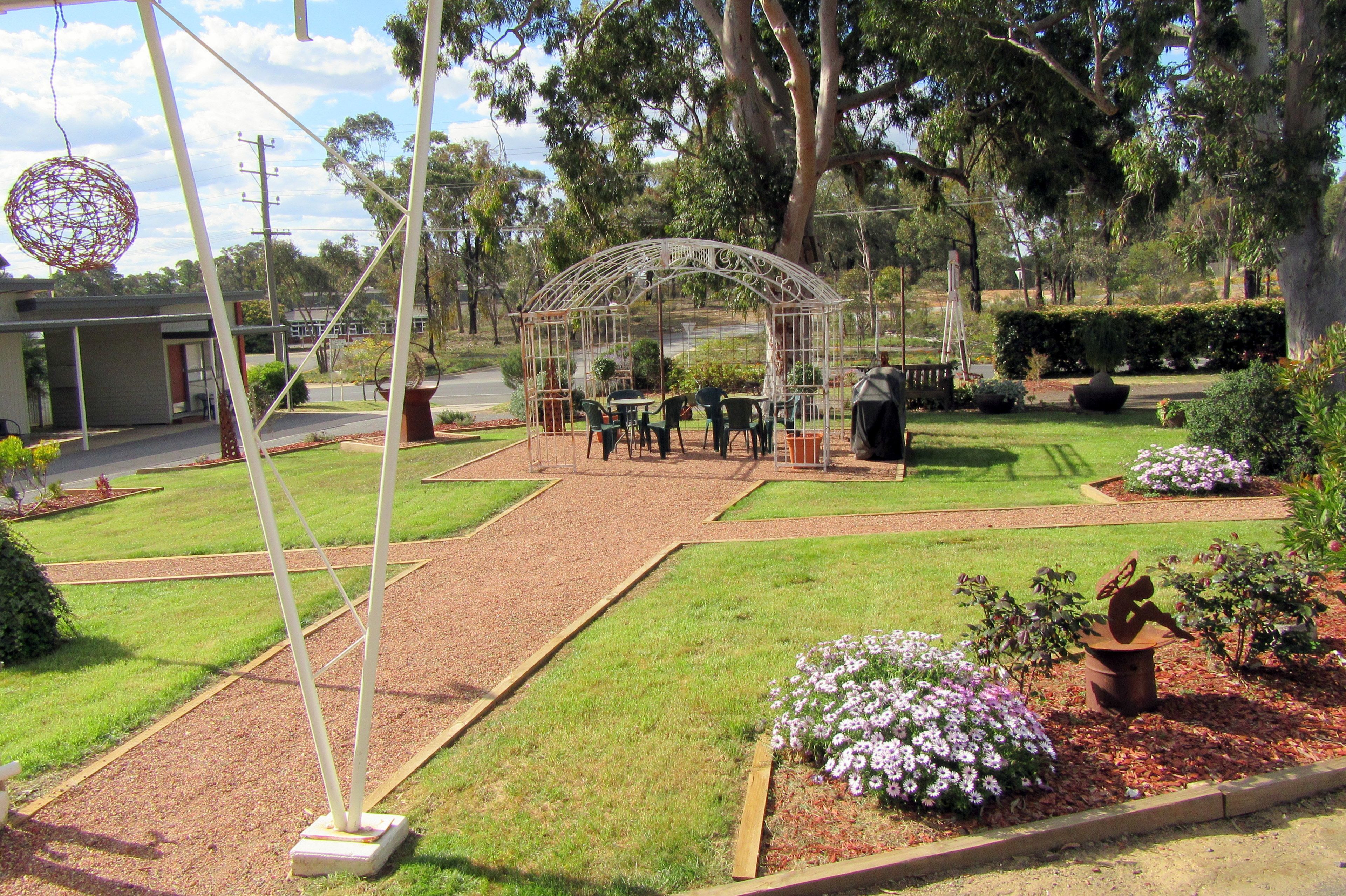 A garden with a gazebo, pathways, and various plants.