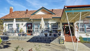 A building with a red-tiled roof, a balcony with outdoor seating, and a sign indicating a motel. - The Highlander Motel - 24HR Check In (Maryborough)