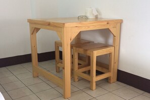 A wooden table with a glass top and a matching stool. - NR Guesthouse (Bangkok)