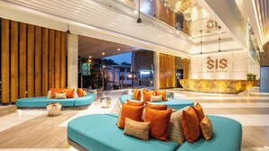 Eine moderne Lobby mit türkisfarbenen Sofas, Holzelementen und einem gut sichtbaren 'SIS'-Schild.