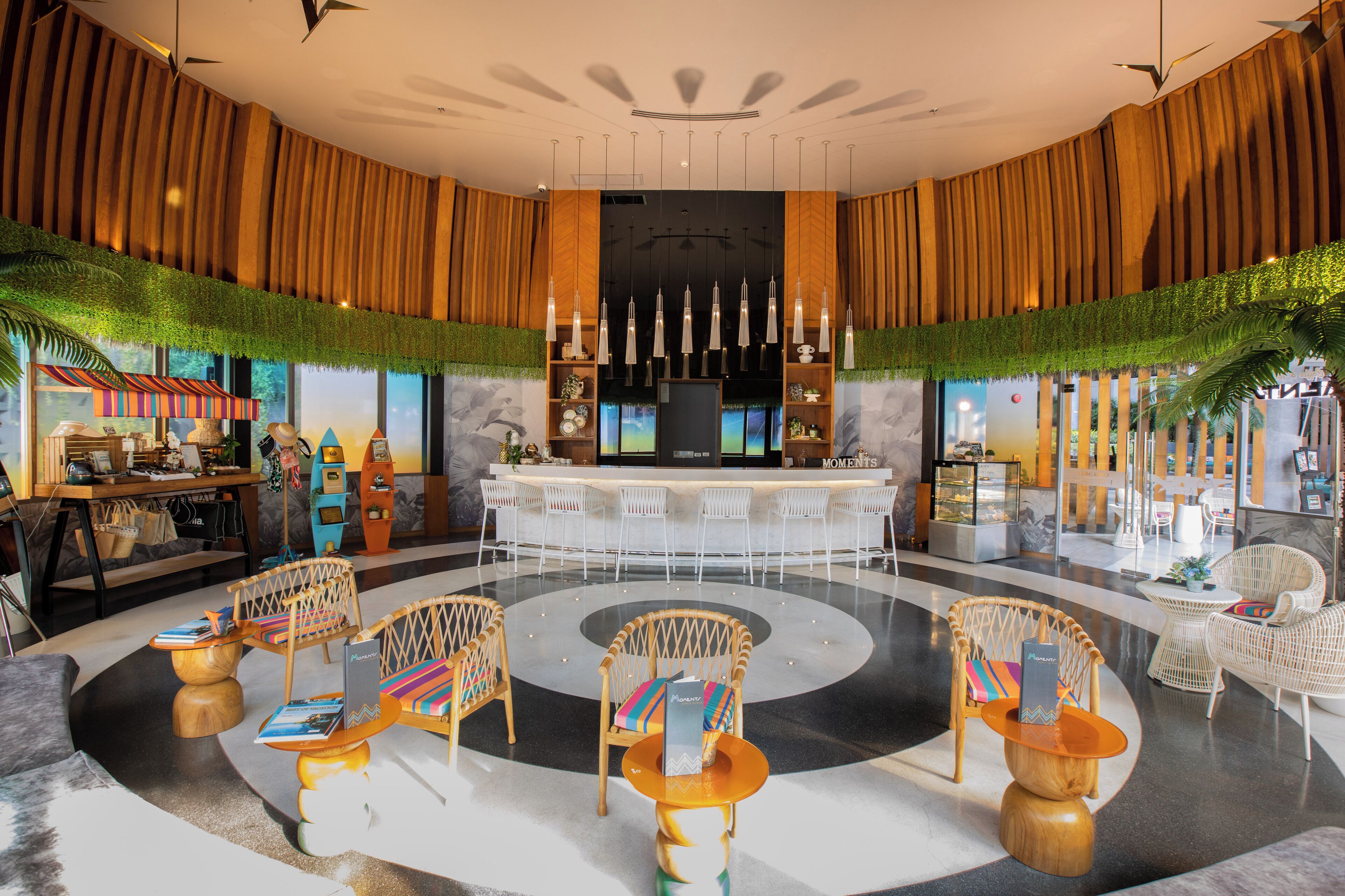 Un vestíbulo con una zona de bar central, disposición de asientos y un mostrador de recepción.