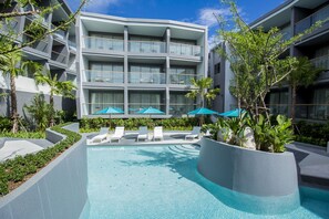 A modern hotel with a pool area, multiple balconies, and lush greenery. - The SIS Kata Resort - Adult Only (Karon)