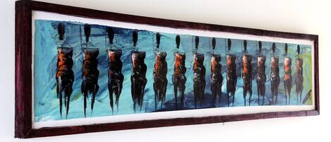 Obra de arte enmarcadas con figuras abstractas dentro de un marco oscuro.