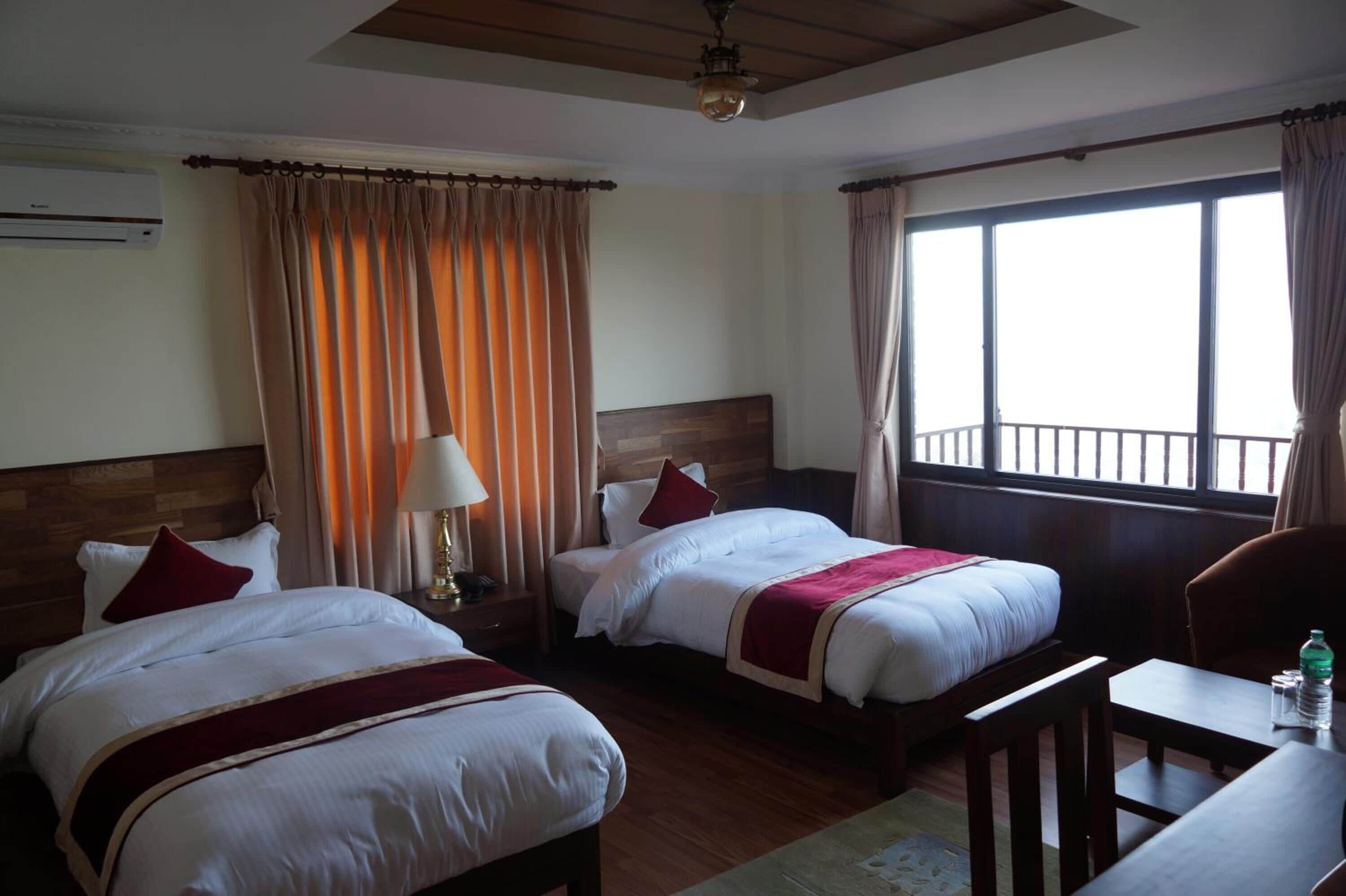 Une chambre d’hôtel avec deux lits, une table de chevet, une table et une chaise.