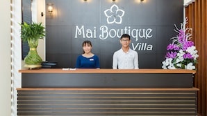Un comptoir d’accueil avec une pancarte indiquant « Mai Boutique Villa ».